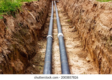 Installation of the distribution unit of heating and water supply network. Frame for connecting pipes in the trench of ground - Shutterstock ID 2003857826