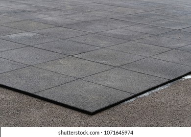 Installation of elastic EPDM synthetic rubber pavement on existent asphalt surface as playground flooring. EPDM safety mats reduce the injury risk caused by falls on playgrounds and sport facilities. - Shutterstock ID 1071645974