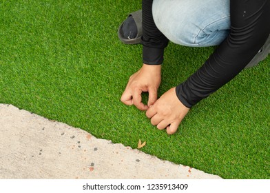 Installation Of Green Artificial Grass. Worker Install Soft Artificial Turf On Backyard