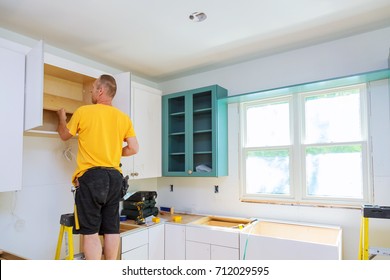 Installation Of Kitchen. Worker Installation Of Kitchen Cabinet.