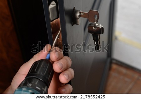 Installation of a lock and door handle to an interior door, a locksmith works with the door, the keys are in the door lock.