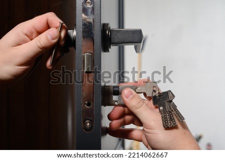 Installation of a lock and door handle to an interior door, a locksmith works with the door, the keys are in the door lock.