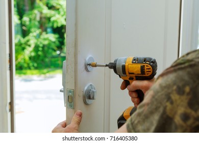 Installation locked interior door knobs, close-up woodworker hands install lock. installation of a lock at the door