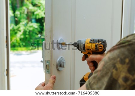 Installation locked interior door knobs, close-up woodworker hands install lock. installation of a lock at the door