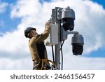 Installation and maintenance of outdoor CCTV cameras. CCTV cameras on the city street. A specialist installs street video surveillance on a pole.