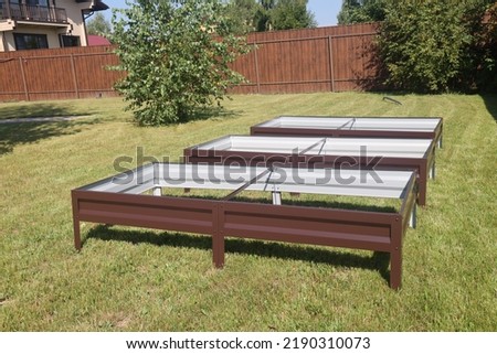 Installation of metal beds for vegetables in the garden. Metal beds for vegetables on the lawn.