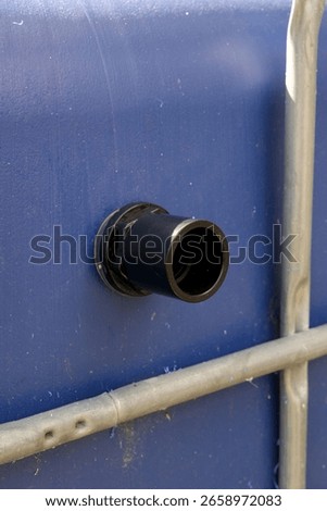Installation of an overflow pipe  in a blue IBC tank, for a rainwater harvesting system.