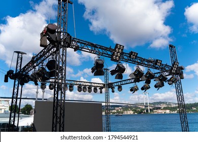 Installation of professional sound, light, led panel, video and stage equipment for a concert. Stage lighting and sound equipment is clamped on a truss for lifting. Flight cases with cables.