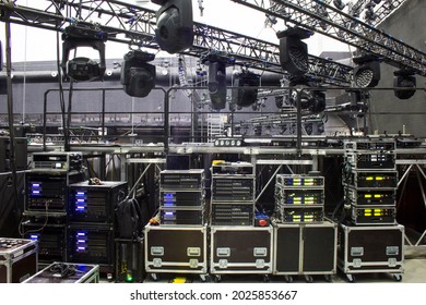 Installation of professional sound, light and stage equipment for a concert. Backstage and tech zone with rack amplifiers, audio signal splitters, radio microphone systems and flight cases.