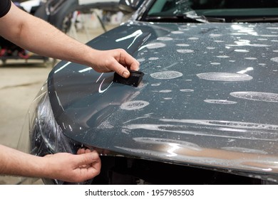 Installation of a protective paint and varnish transparent film on the car. PPF polyurethane film to protect the car paint from stones and scratches. - Shutterstock ID 1957985503