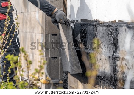 installation of protective waterproofing on the foundation and walls of the building. warmed by an open fire
