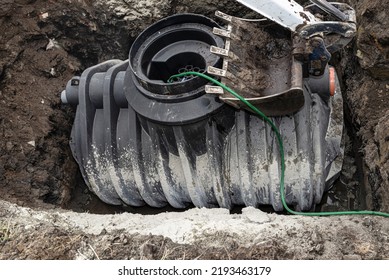 Installation Of A Single-chamber Home Sewage Treatment Plant, The Excavator Presses The Tank.