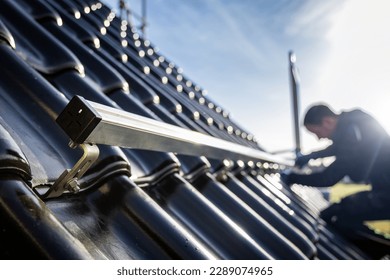 Installation of solar panel support structures on a tiled roof