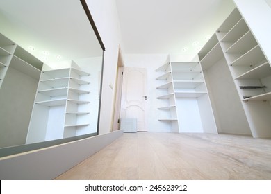 Installation of white corner sliding wardrobe and its reflection in mirror