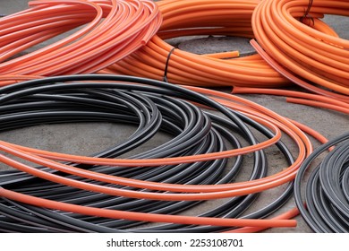 Installations and development of Communications, Large coils reel of PVC pipe tube plastic. tubing on construction site, protect electrical cables underground. - Shutterstock ID 2253108701