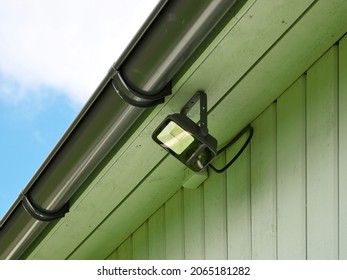 Installed LED Floodlight Under The Roof Of A Wooden House.