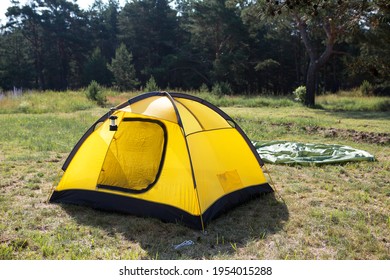 Installed tourist tent and a camping lantern in nature in the forest. Domestic tourism, active summer holidays, family adventures. Ecotourism, social distance. Copy space