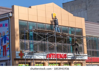 Installers Attach The Store Sign To The Facade Of The Building. Dzhankoy, Crimea, 8.11.2020