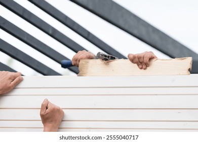 Installing and aligning boards in grooves when installing a wall in a gazebo, construction work and moments during the construction of a gazebo. - Powered by Shutterstock