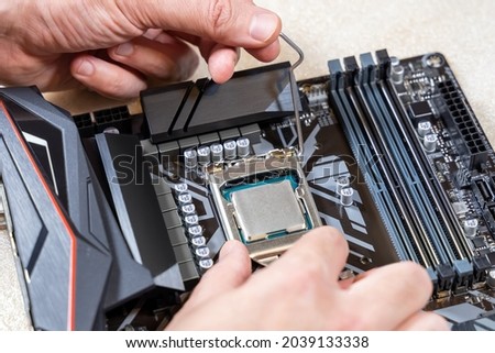 Installing a blank central processor on a motherboard. The blank CPU is installed in the motherboard connector. DIY PC assembly or upgrade