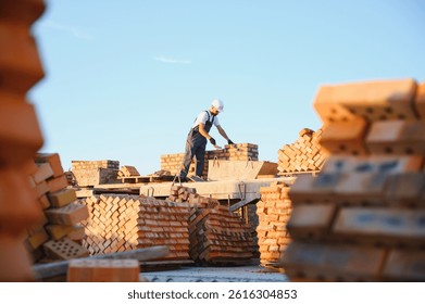 Installing brick wall. Construction worker in uniform and safety equipment have job on building.