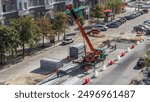 Installing concrete plates by crane at road construction site timelapse. Aerial top view. Industrial workers with hardhats and uniform. Reconstruction of tram tracks in the city street