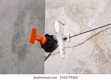 Installing leveling system tiles on wall.