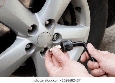 Installing locking lug nut using special key. Prevents unauthorized wheel removal.