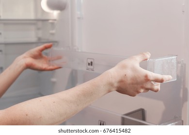 Installing New, Clean Shelves In An Empty Washed Refrigerator. 