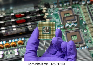 installing a new processor in a computer, gloved hand holds a cpu against the background of computer parts