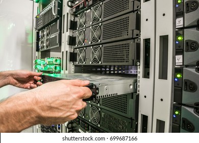 Installing a new server in the server datacenter rack. Repair of powerful Internet equipment. Engineering work in the server room is the data center.