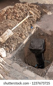 Installing A New Water Meter In The Road. UK. The New Black Plastic Housing Situated In A Hole In The Ground.