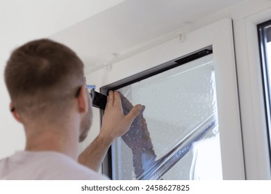 Installing process of tint glass film to window. Ultraviolet and heat protection concept. 