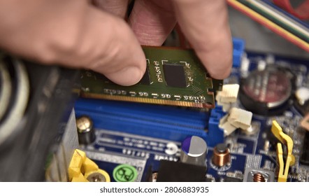 Installing RAM memory module into a computer motherboard slot close up