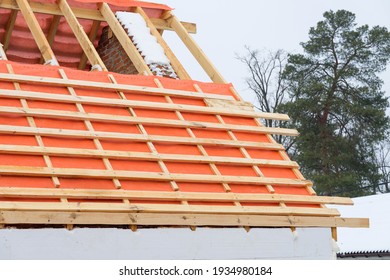 Installing roof boards and vapor barriers for metal tiles in winter time. - Shutterstock ID 1934980184