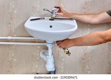 Installing Single Lever Faucet On Washroom Sink, Plumber Inserts Water Tap Into Washbasin Hole.