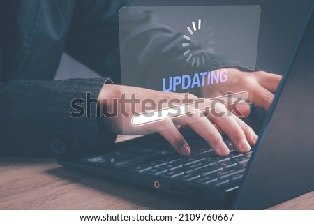 Installing software update process, operating system upgrade concept. Hand using laptop with Installing app patch or app new version updating progress bar on virtual screen. [[stock_photo]] © 