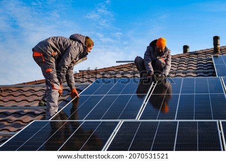Installing a Solar Cell on a Roof. Solar panels on roof. Workers installing solar cell farm power plant eco technology.