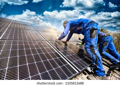 Installing solar photovoltaic panel system. Solar panel technician installing solar panels on roof. Alternative energy ecological concept. - Shutterstock ID 2105812688