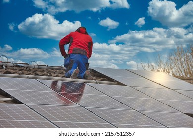 Installing solar photovoltaic panel system. Solar panel technician installing solar panels on roof. Alternative energy ecological concept. - Shutterstock ID 2157512357