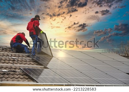 Installing solar photovoltaic panel system. Solar panel technician installing solar panels on roof. Alternative energy ecological concept.
