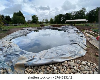 Installing A Swimming Pond. Black Liner Filled With Water. Backyard Pond Project.