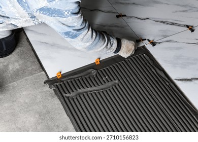 Installing the tiling system (clips) before laying tiles.