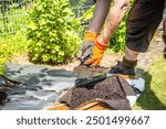 Installing weed control fabric material and bark mulch in a residential garden to control weed spreading