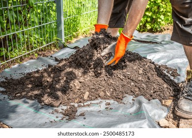 Installing weed control fabric material and bark mulch in a residential garden to control weed spreading