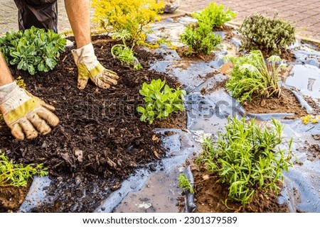 Installing weed control fabric material and bark mulch in a residential garden to control weed spreading