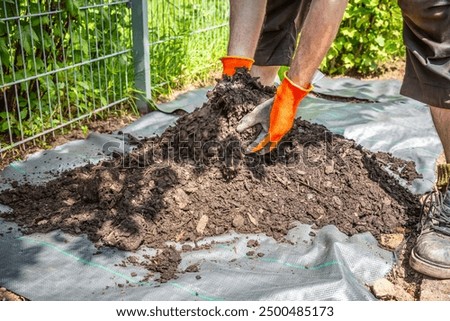 Installing weed control fabric material and bark mulch in a residential garden to control weed spreading