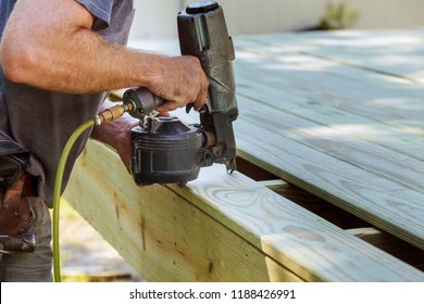 Installing Wood on deck, patio construction man using pneumatic gun