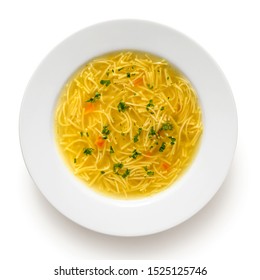 Instant chicken noodle soup in a white ceramic soup plate isolated on white. Top view. Chopped parsley.