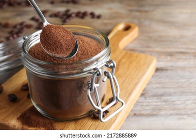 Instant Coffee And Spoon Above Glass Jar On Wooden Table, Closeup. Space For Text